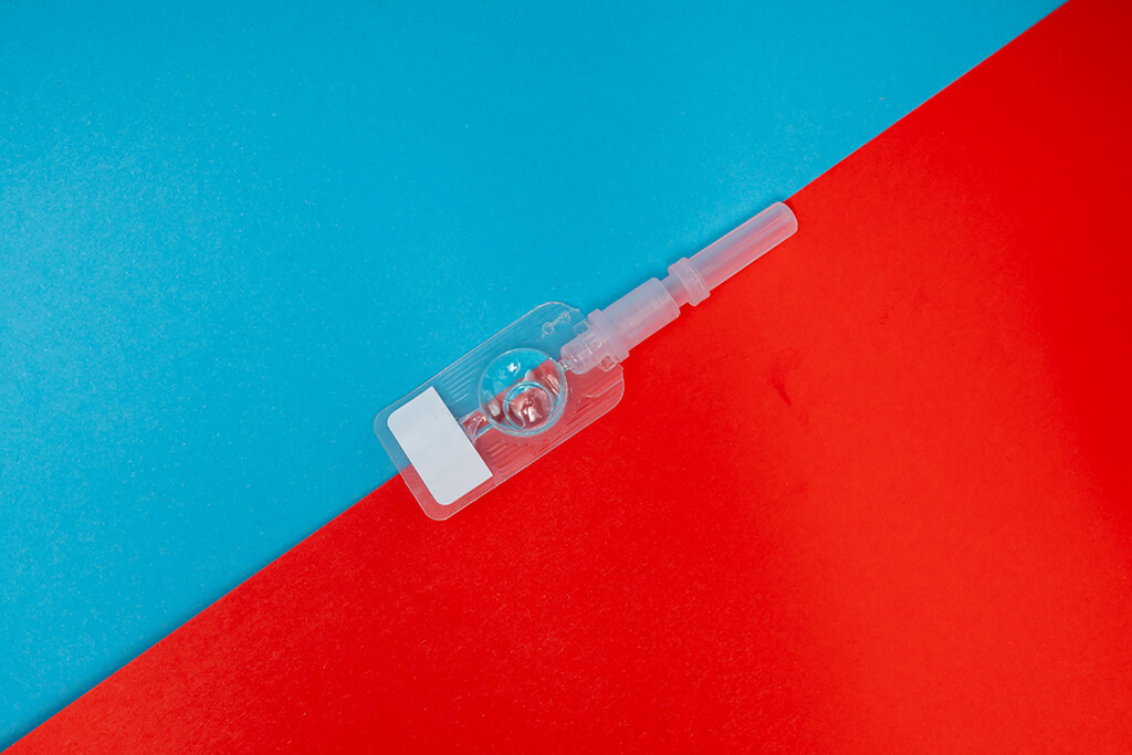 Iniezione contraccettiva su sfondo azzurro e rosso foto